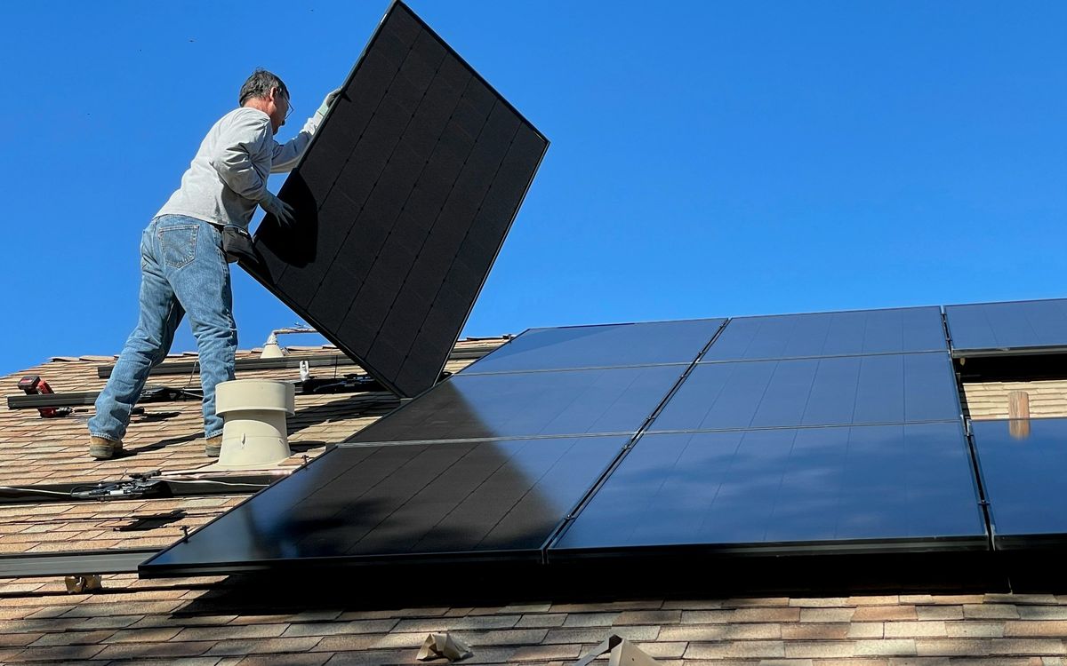 Técnico instalando paneles solares sobre un techo
